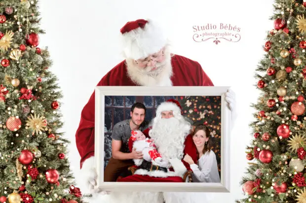 Sant Claus tient un cadre dans lequel on voit une photo de famille avec le Père Noël